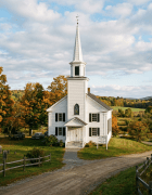White church with steeple, cemetery, and autumn countryside
